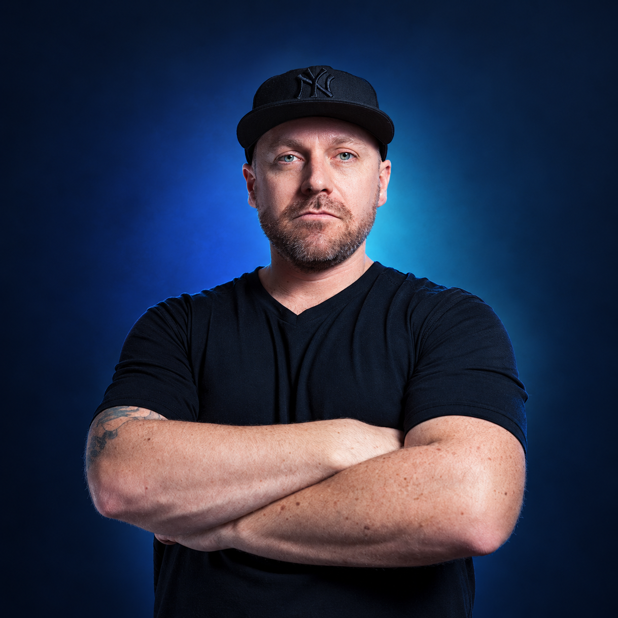 DJ Adverse studio portrait against a navy and aqua background